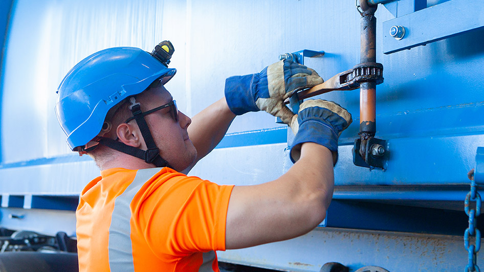 Kypäräpäinen henkilö huoltotöissä.